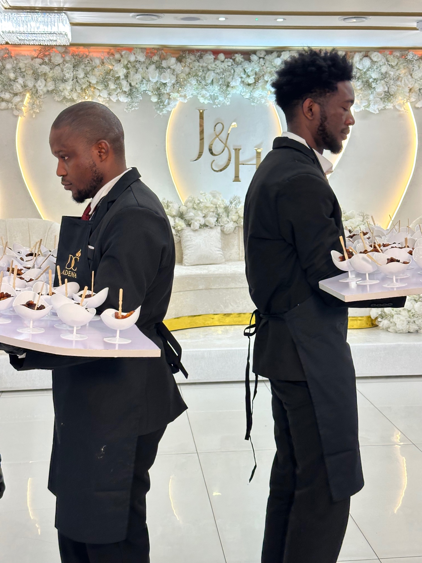 Servers carrying canapé trays at a wedding reception
