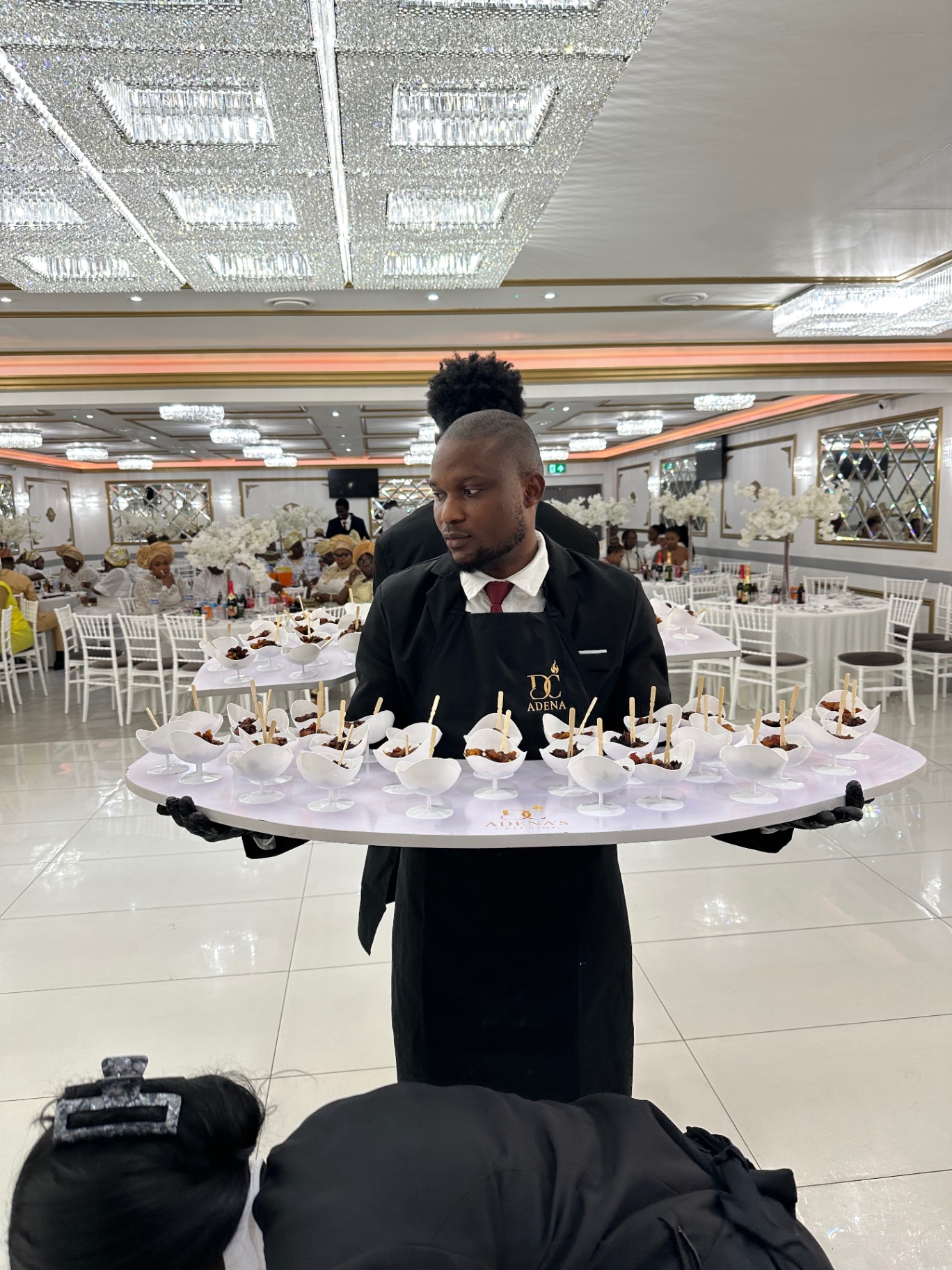 Waiter presenting a tray of canapé cups in the banquet hall