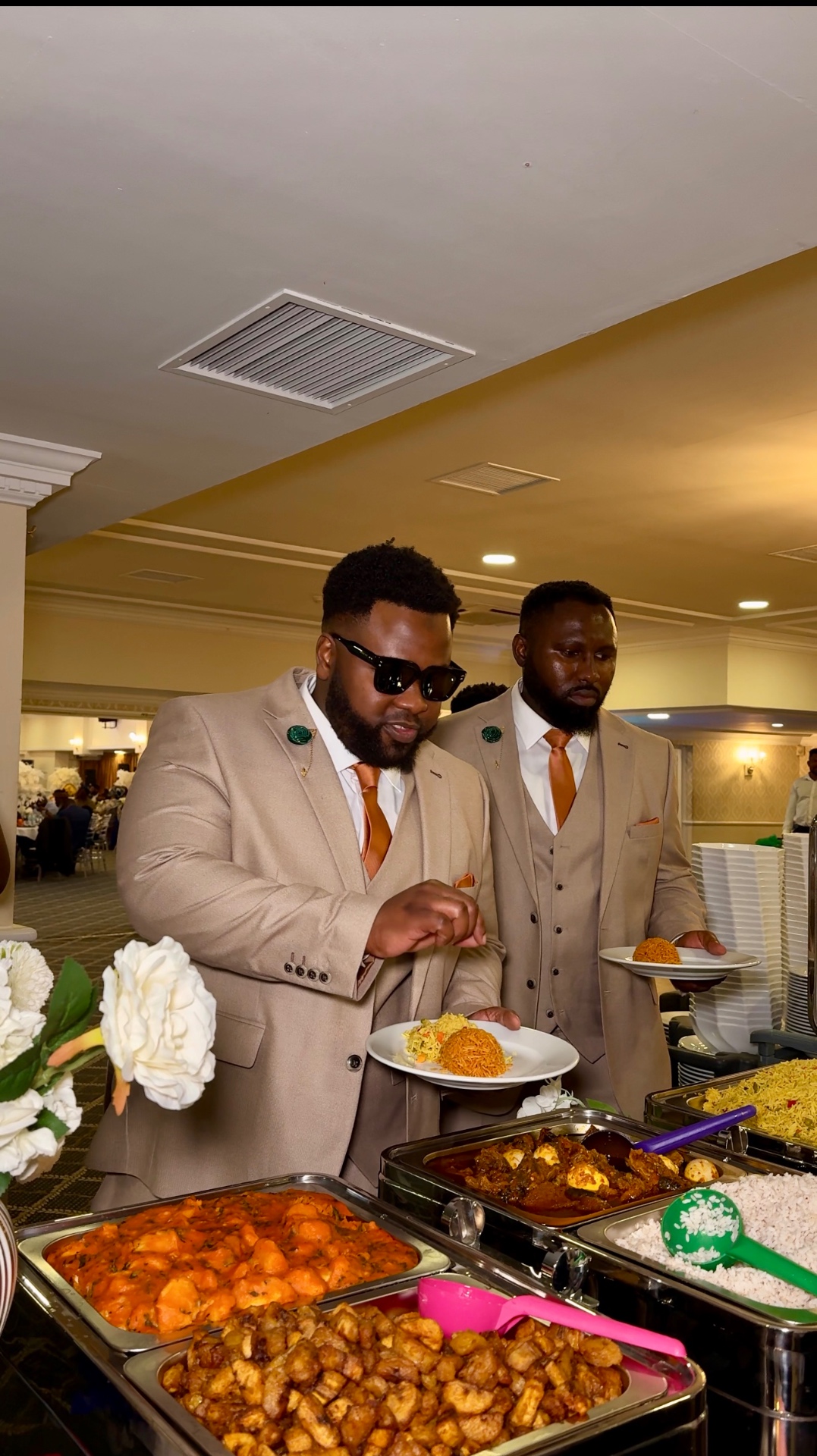 Guests serving themselves from a formal buffet in eveningwear