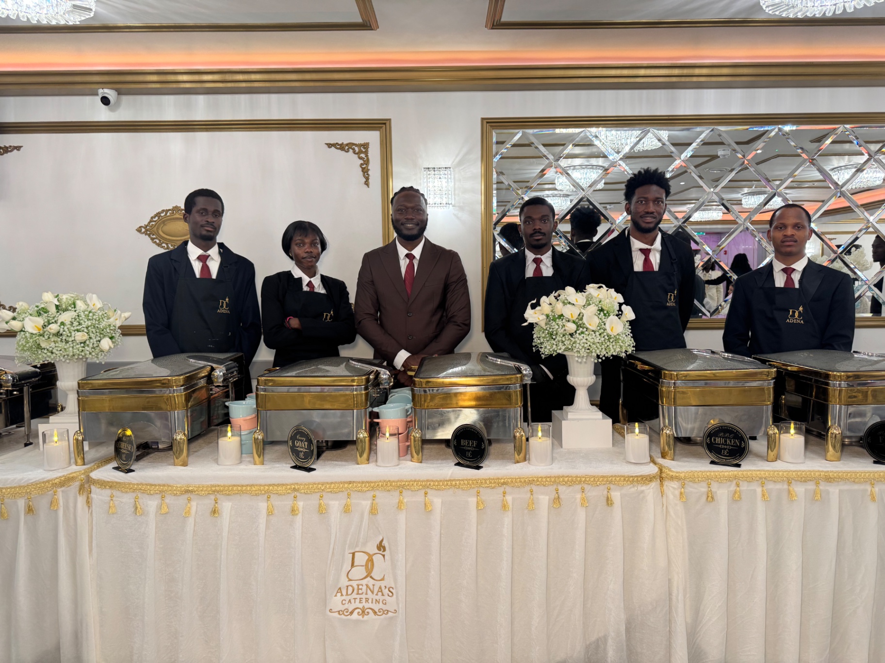 Adena's catering team behind a gold-trimmed buffet line