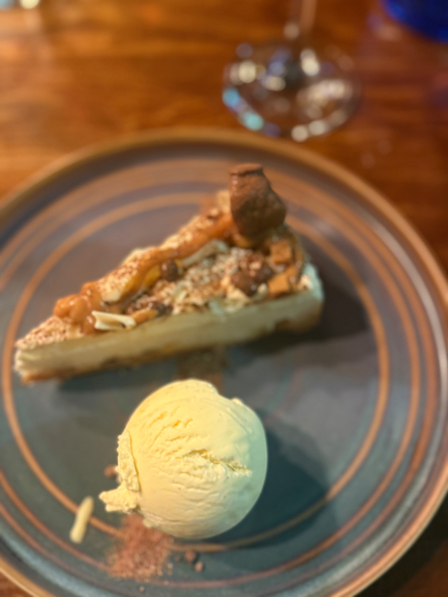 Cheesecake slice with vanilla ice cream and caramel garnish