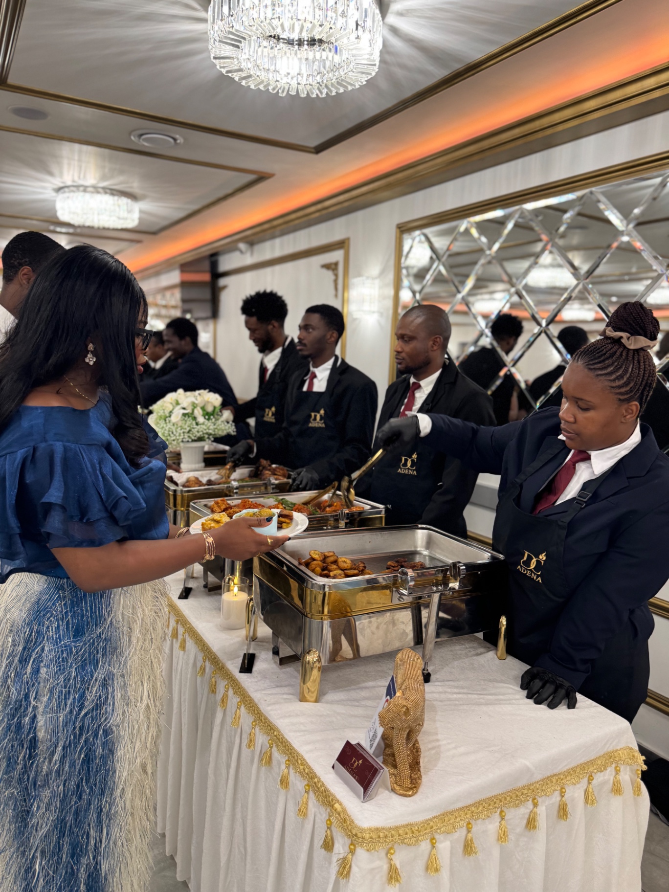 Guests served at an elegant chandelier-lit buffet