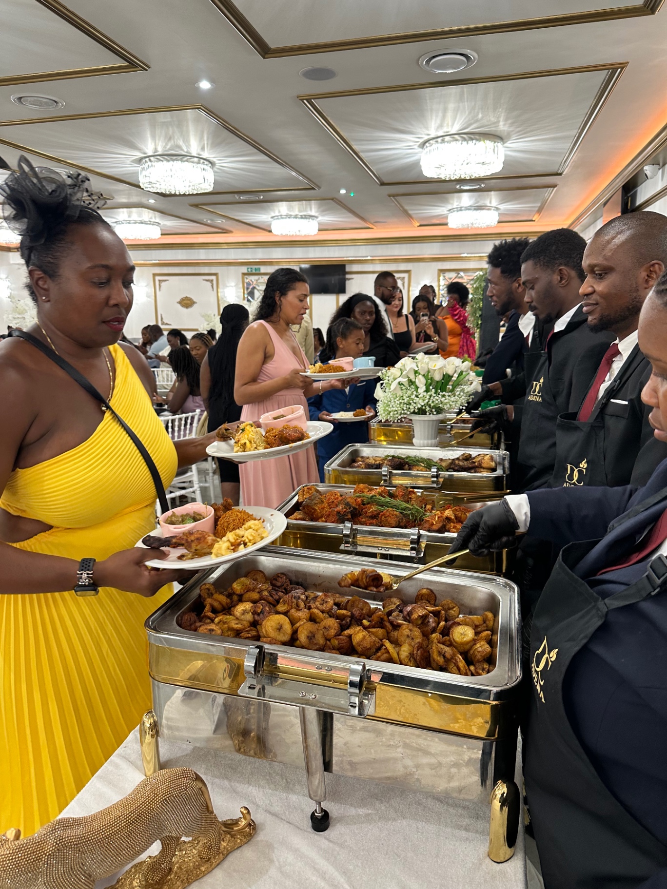 Buffet service of jollof, plantain and grilled meats at a wedding